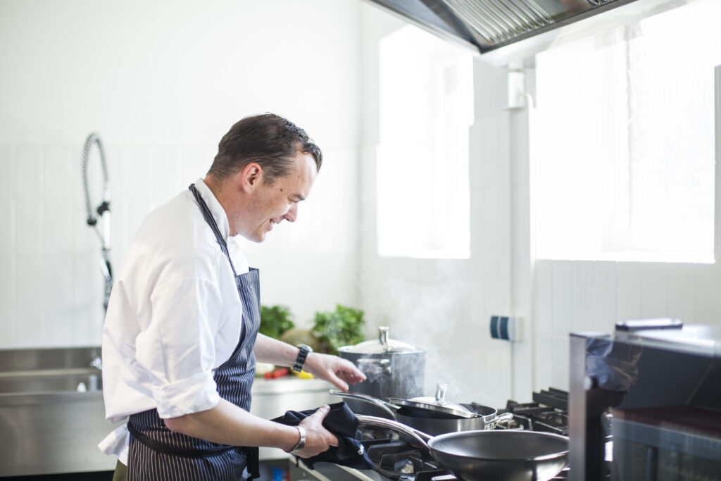 Ein Koch bereitet Essen in einer Küche zu